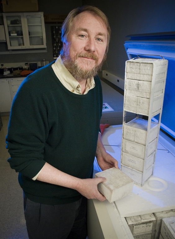 Dr. Richard Lenski standing beside a freezing rack. 