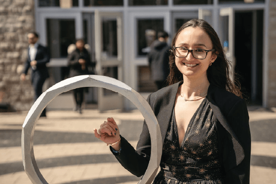 Young woman standing with the Iron Ring statue