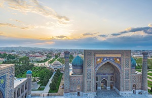 Ariel view of the a grey city in Uzbekistan with sun setting in the background