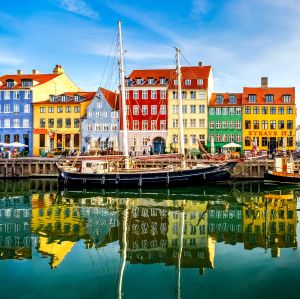 Boats tied up along a warf with colourful buildings in background