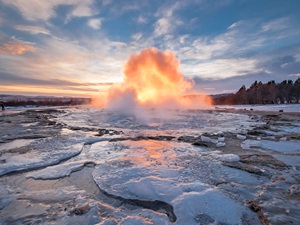 A geyser exploding out of an icy surface in Iceland