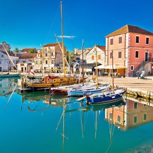 Sail boats in a harbour with colourful buildings in the background